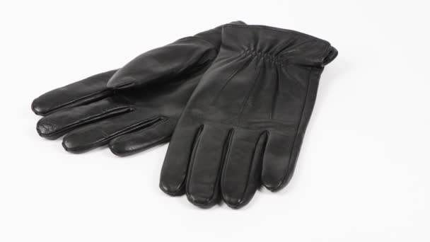 Zwart paar leren handschoenen geïsoleerd op wit. Zijaanzicht. 4K UHD-videobeelden 3840X2160. - Video