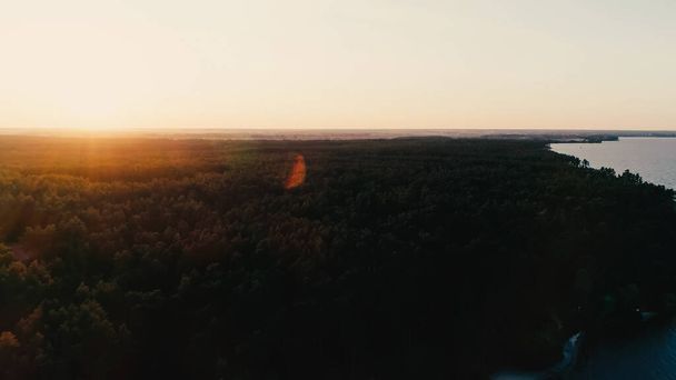 Вид з повітря на ліс і річку на заході сонця
  - Фото, зображення