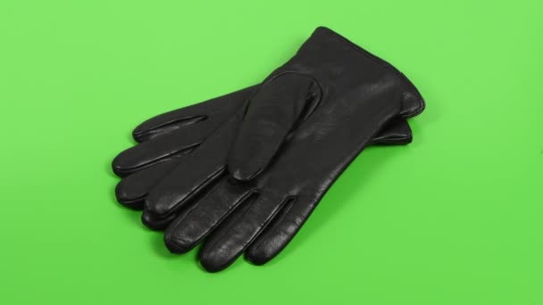 Schwarze Lederhandschuhe auf grünem Chromaschlüssel. Seitenansicht. 4K UHD Videomaterial 3840X2160. - Filmmaterial, Video