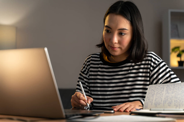 Bájos fiatal nő designer rajz a tabletta használata közben laptop otthon. Tanulási koncepció. Készletkép - Fotó, kép