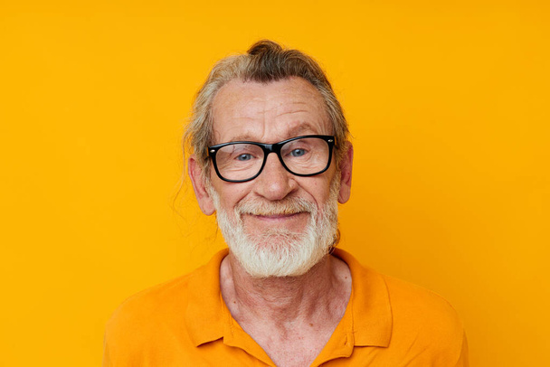 cheerful old man gray beard glasses yellow background - Fotó, kép