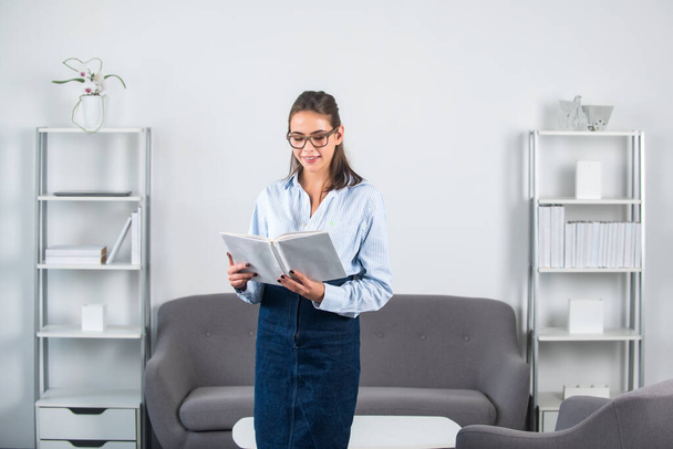 Young business woman freelancer or ceo employee holding note book or notepad in office. - Foto, afbeelding
