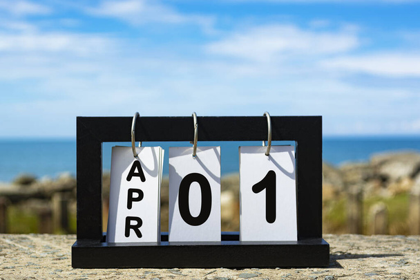 Apr 01 calendar date text on wooden frame with blurred background of ocean. Calendar concept - Foto, afbeelding
