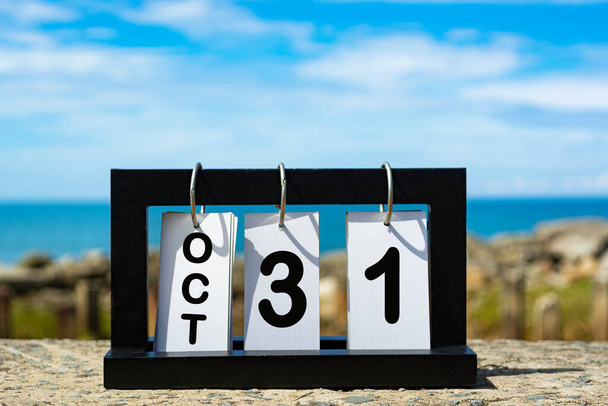 Oct 31 calendario fecha texto sobre marco de madera con fondo borroso de océano. Concepto calendario - Foto, imagen