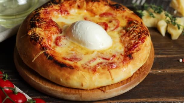 Le cuisinier saupoudrer de parmesan et décorer de thym pizza maison avec une boule de mozzarella et de croûte cuite au four - Séquence, vidéo