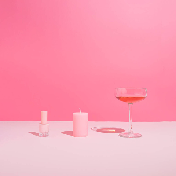 Set rosa pastello girly con smalto per unghie, candela romantica e bicchiere di vino rosa. Estetica moderna di San Valentino. - Foto, immagini