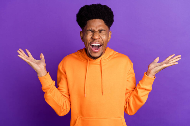 Photo of angry young afro american man bad mood scream hold hands negative isolated on purple color background - Foto, afbeelding