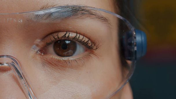 Femme avec des lunettes de protection montrant un œil devant la caméra - Photo, image