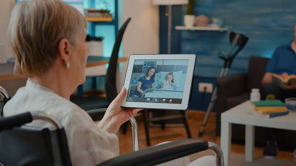 Persona anziana in sedia a rotelle tablet con videochiamata online - Foto, immagini