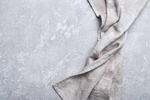 Top view of single folded linen serviette on grey concrete background - Foto, immagini