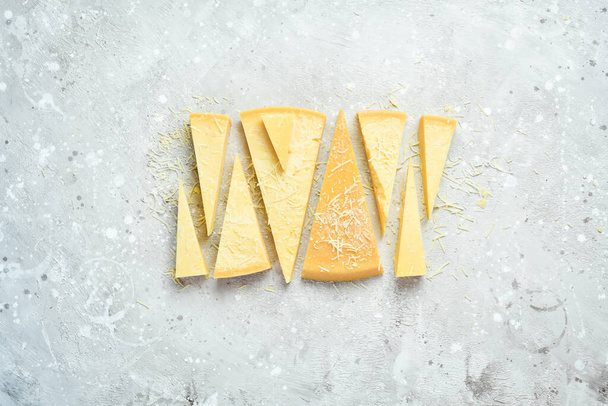 Cheese background. Triangular pieces of hard cheese on a stone background. Parmesan. Free space for text. - Valokuva, kuva