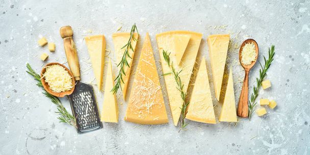 Cheese background. Triangular pieces of hard cheese on a stone background. Parmesan. Free space for text. - 写真・画像