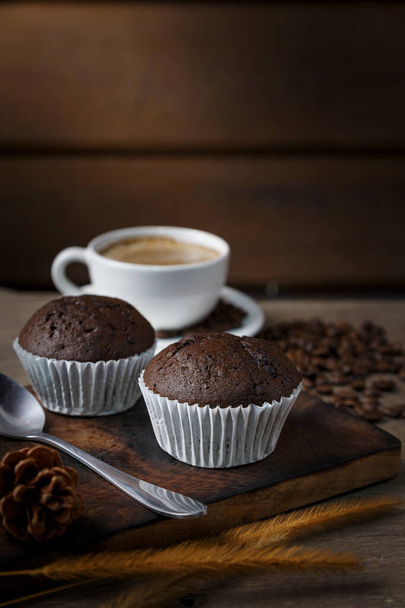 午前中に提供されるコーヒーとチョコレートカップケーキ. - 写真・画像