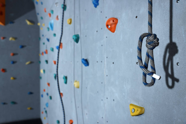 Climbing rope and colorful wall with holds in gym, space for text - Fotografie, Obrázek