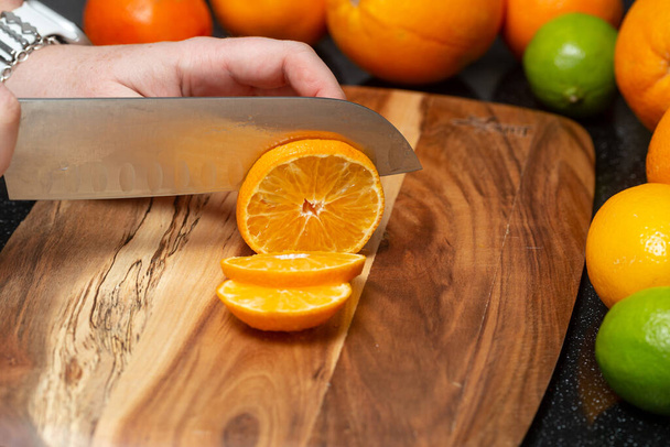 Fresh orange is cut into slices on a cutting board - Foto, afbeelding