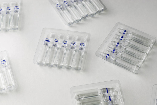 plastic transparent containers with glass ampoules on a white background. High quality photo - Foto, Imagem