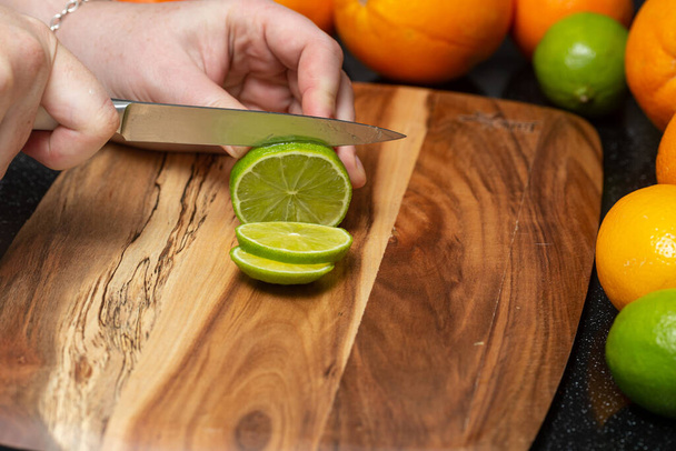 Fresh lime cut into slices, lying on a cutting board - Foto, afbeelding