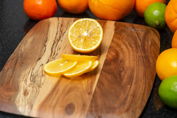 Fresh lemon is cut into slices, lying on a cutting board - 写真・画像