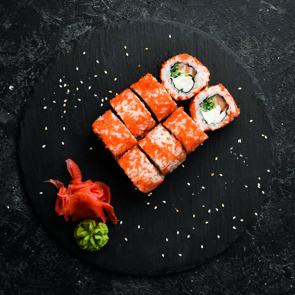Rollos de sushi con caviar. Comida tradicional japonesa. En un plato de piedra negra. Vista superior. - Foto, Imagen