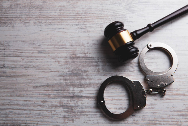 молоток судьи и наручники на столе - Фото, изображение