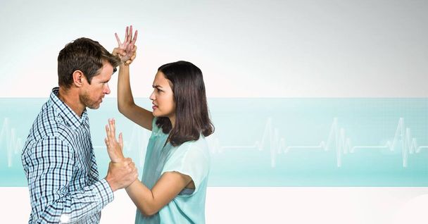 Caucasian couple fighting against against heart rate monitor with copy space on grey background. medical research and science concept - Фото, зображення