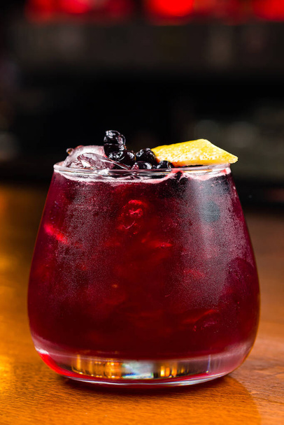 red cocktail with fresh berries and lemon slice. Fresh red water with lemon and blueberries. Exotic summer drink with citrus slices. Red berry or fruit lemonade - Foto, imagen