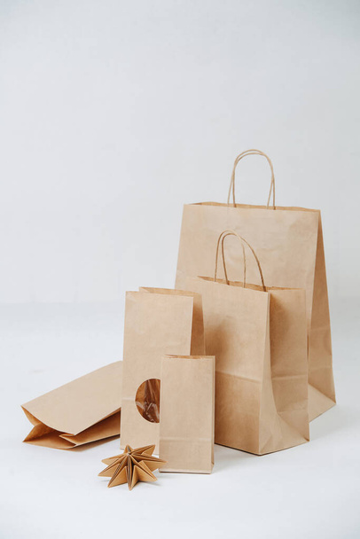 Row of paper bags increasing in size over white background. Composition. Eco friendly compostable packaging. - Fotoğraf, Görsel