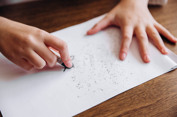 Kobiece ręce wymazują napis stres gumką z białego arkusza papieru - Zdjęcie, obraz