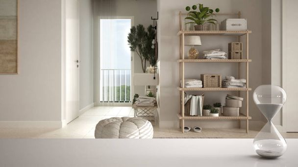 Biały stół lub półka z kryształową klepsydrą mierzącą czas przelotu nad minimalistyczną łazienką, zlewem i półkami, roślinami doniczkowymi, architektonicznym wystrojem wnętrz, tłem przestrzeni do kopiowania - Zdjęcie, obraz