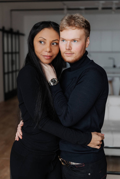 jong getrouwd multiraciaal paar genieten van de luxe interieur van hun nieuwe appartement - Foto, afbeelding