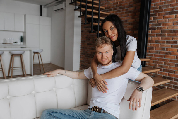 Young african woman hugging boyfriend in their new apartment after buying real estate - Фото, изображение