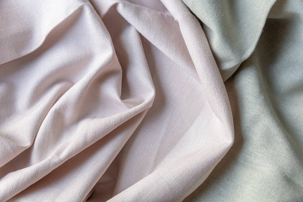 Texturált redők vászon szövet pasztell rózsaszín és zöld színekben. Textil háttér, felülnézet, szerves ruha - Fotó, kép