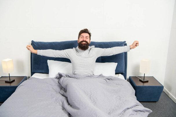 Happy guy smiling and stretching in bed waking up after sleep, morning - Foto, Imagem