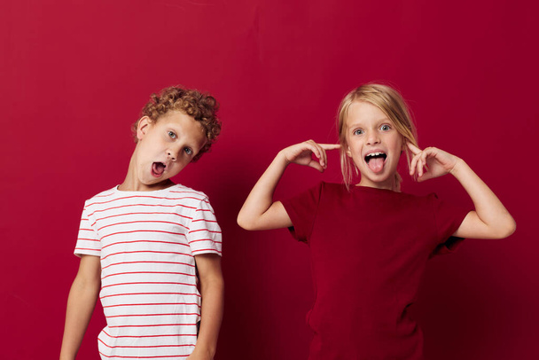 Cute preschool kids smiling and posing in casual clothes against red background - Foto, immagini