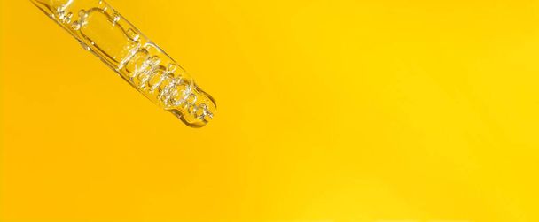 Banner of pipette with hyaluronic acid or serum on yellow orange background. Cosmetics and healthcare concept closeup - Foto, immagini