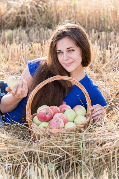 Teen girl with a basket of apples in  field - Zdjęcie, obraz