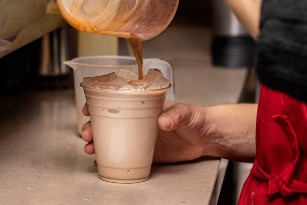 Kahve barmeni bir müşteriye buzlu içecek yapıyor. - Fotoğraf, Görsel