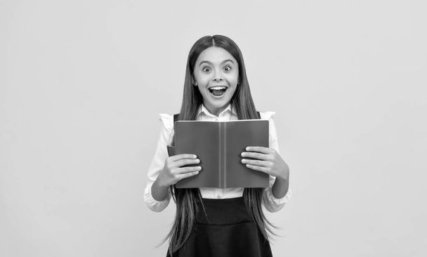 surprised teen girl in school uniform reading book, amasement - Photo, Image