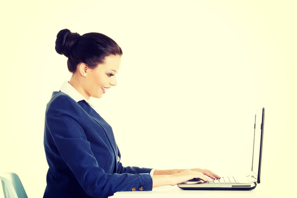 Beautiful brunette businesswoman working on laptop - Фото, зображення