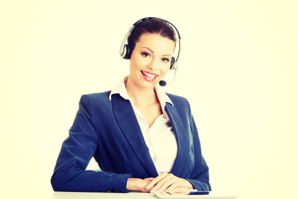 Beautiful young call-center assistant at the desk - Foto, Imagen