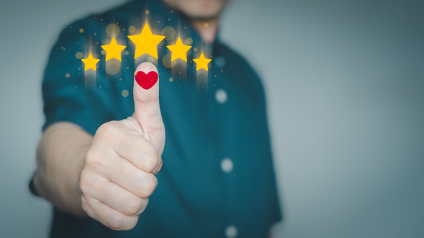 Man's hand with red heart icon and golden five stars. Concept of satisfaction in the customer experience in using the service. - Photo, Image