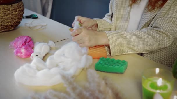 Close-up of a beautiful red-haired girl, she rolls wool and creates toys. Handmade work - Footage, Video