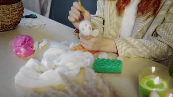 Close-up de uma linda menina ruiva, ela rola lã e cria brinquedos. Trabalho artesanal - Filmagem, Vídeo