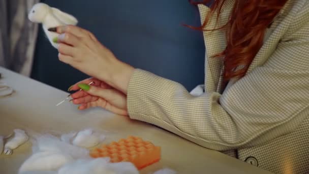 Close-up van een prachtig roodharig meisje, ze rolt wol en maakt speelgoed. Handgemaakt werk - Video