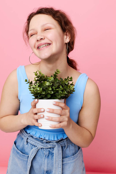 funny girl in a blue T-shirt and shorts a flowerpot isolated backgrounds unaltered - Fotografie, Obrázek