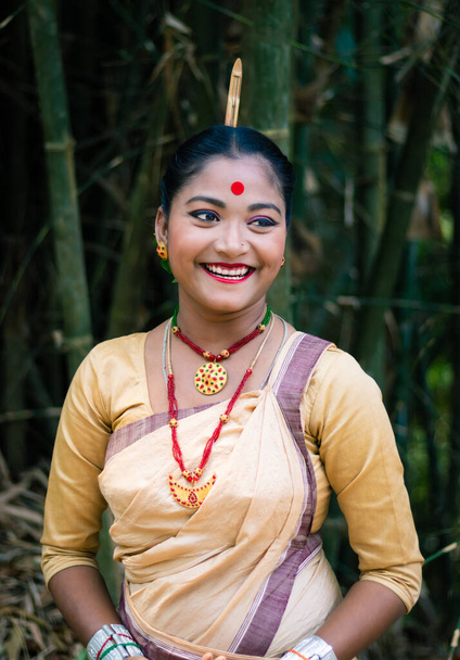meisje glimlachen gezicht geïsoleerd gekleed in traditionele dragen op festival met wazig achtergrond afbeelding wordt genomen ter gelegenheid van bihu op assam india. - Foto, afbeelding