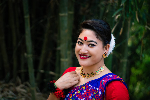 Девушка улыбается лицо изолированы одеты в традиционном ношении на фестивале с размытым фоном изображение принято по случаю bihu на assam Индии. - Фото, изображение