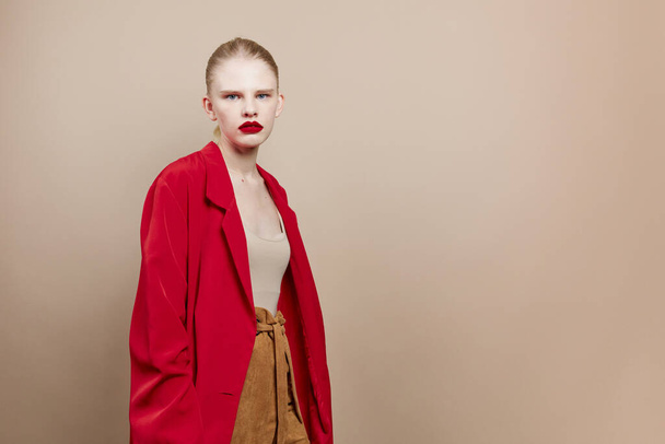 maquillaje de mujer de moda en el fondo beige chaqueta roja - Foto, imagen