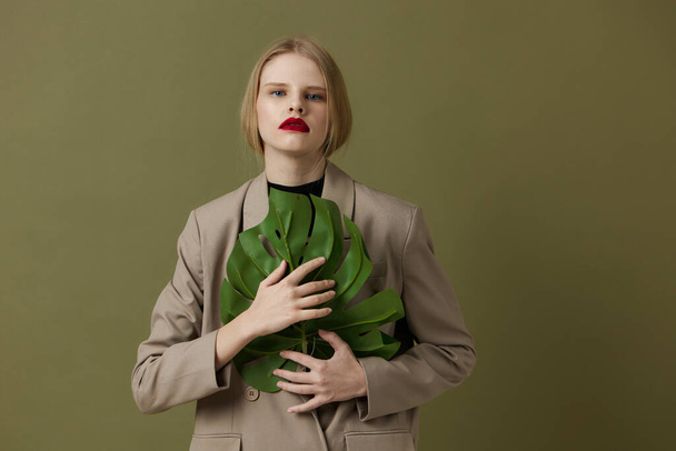 λαμπερό γυναίκα πράσινο παλτό φύλλο παλάμη φωτεινό μακιγιάζ Lifestyle θέτοντας - Φωτογραφία, εικόνα
