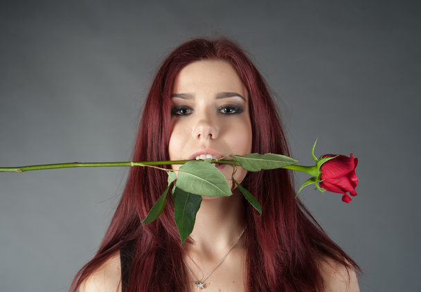 girl with a rose in his teeth - Fotó, kép